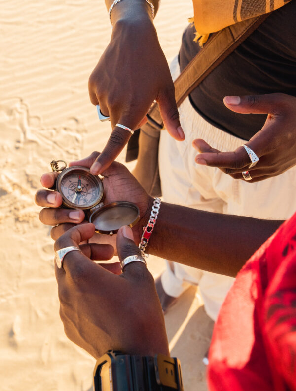 pathfinders in the desert wearing urban sterling 940 argentium rings and chains and seiko snk807 and holding compass